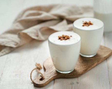 Two cups of creamy and nourishing milk kefir in glass jars.